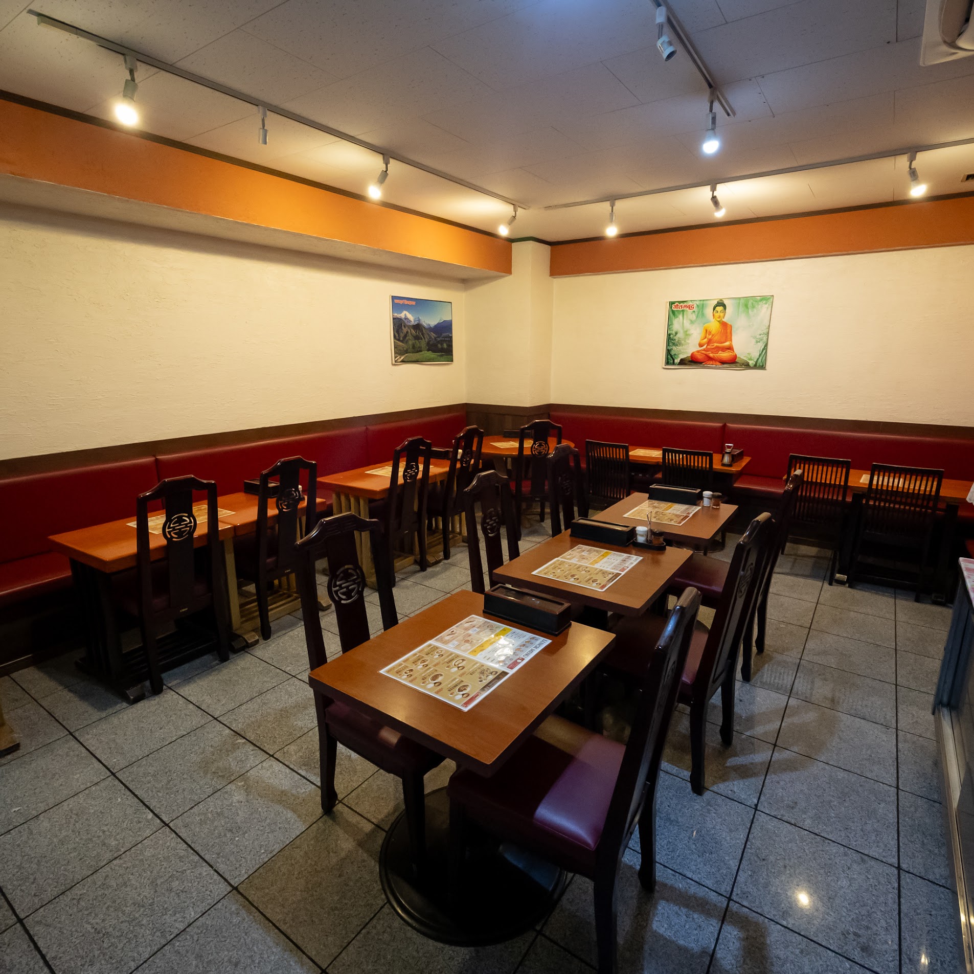 木のテーブルと赤いベンチ席が並ぶマジックキッチンの店内